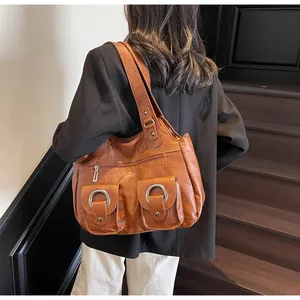 Brown vintage faux leather tote bag showing side view on model shoulder with metal rings