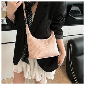 Detailaufnahme einer hellrosa Hobo-Tasche mit Wellentextur an einem weiblichen Model