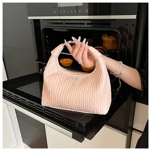 Detail einer hellrosa plissierten Lederhandtasche mit Metallverschluss in Nahaufnahme