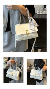 Detail of white woven leather handbag featuring elegant scarf handle and gold buckle