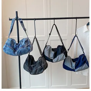 Selection of retro denim hobo bags with pleated texture and adjustable straps shown on rack