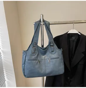 Detail van de grote matblauwe shopper met leerstructuur en metalen ritsen