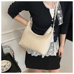 Detailansicht der beige Hobo-Tasche mit vertikalen Wellenfalten und silbernen Details