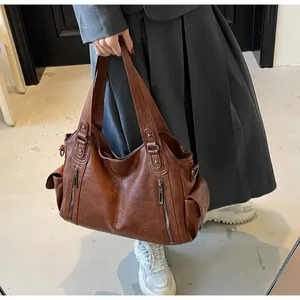 Detail view of brown vintage PU leather tote bag featuring multiple pockets and texture