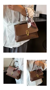 Detail of dark brown woven leather handbag with decorative scarf on the handle