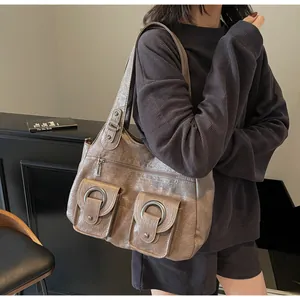Close-up of vintage brown tote bag featuring dual front pockets with metal rings