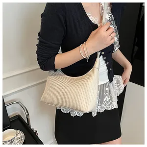 Detailansicht der cremefarbenen Plissee-Schultertasche mit eleganten Texturen und Design