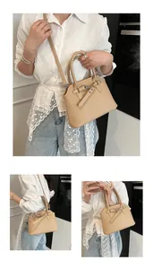 Detailweergave van de beige tote bag met verticale streeptextuur en gespversiering erop
