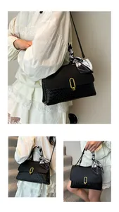 Detail view of black woven handbag featuring golden oval buckle and floral silk scarf decor
