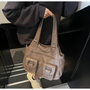 Detail of vintage brown PU leather shoulder bag with metallic rings and pocket texture