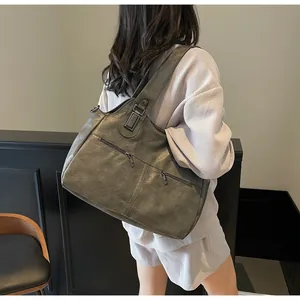 Detailopname van donkergrijze grote shopper van imitatieleer met decoratieve ritsen