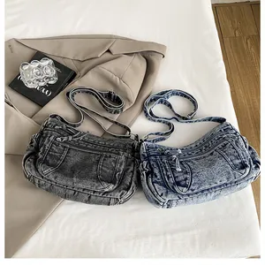 Detail of vintage washed denim crossbody bags with multiple zipper pockets and adjustable straps