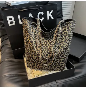 Macro detail of leopard print canvas tote bag with metal logo and sturdy shoulder straps