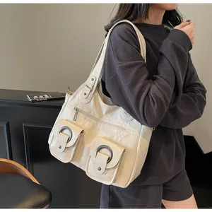 Detail of cream tote bag featuring vintage faux leather texture and dual front pockets