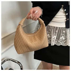 Detail der Plissee-Struktur einer khakifarbenen Hobo-Tasche im sichelförmigen Design