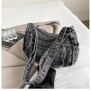 Detail of vintage denim dumpling bag showing retro charcoal wash and zipper pockets
