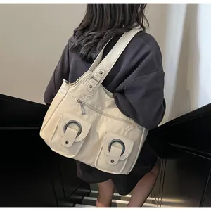 Detailed view of cream tote bag featuring pleated texture and silver buckle pockets