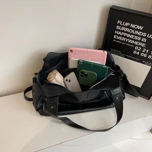 Retro black leather tote bag with large capacity, shown with daily essentials inside