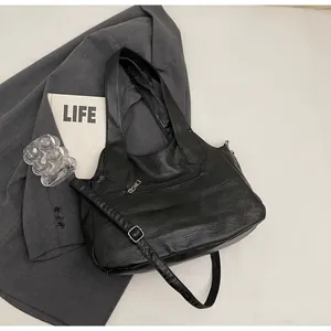 Detailopname van de zwarte vintage tote bag met een handig ritsvak aan de achterzijde