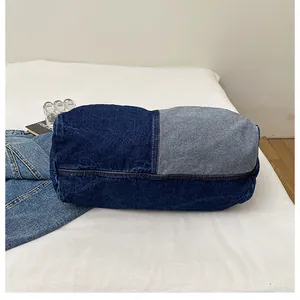 Detail of retro cylinder denim tote bag with blue patchwork stitching and casual texture