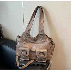 Detail view of retro tote bag with dual metal ring pockets and pleated leather texture