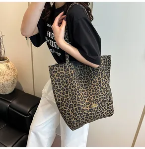 Detail of leopard print canvas tote bag with gold metal plaque and spacious interior