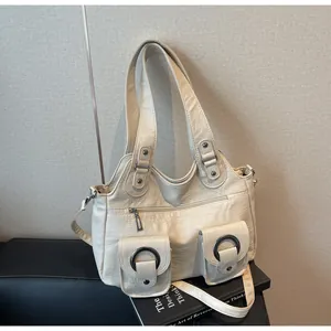 Detail of cream white pleated tote bag with multi-pockets and metal ring accents