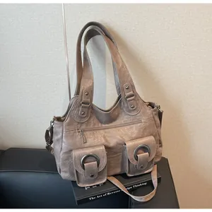 Detail of vintage taupe tote bag showing flap pockets with metal rings and PU leather texture