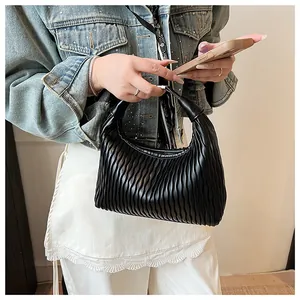 Detail der schwarzen Hobo-Tasche mit vertikalen Falten und poliertem Halbmond-Design