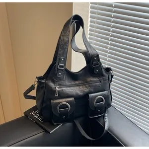 Detail of black vintage PU leather tote featuring two front buckled pockets and silver rings