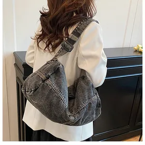 Detailed view of the dark grey denim crossbody bag featuring white contrast stitching