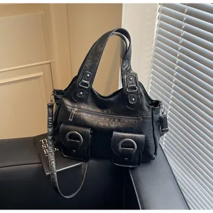 Detail shot of black retro tote bag with large metal ring buckles and textured PU leather