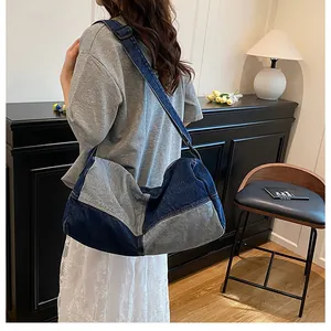 Detail of large denim patchwork tote with adjustable shoulder strap worn by a model