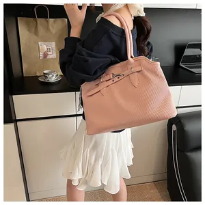 Detailweergave van de roze shopper met verticale plooitextuur en metalen gespdetails