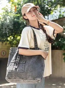 Detail der grauen ausgewaschenen Denim-Tragetasche mit Vintage-Struktur und Schnallentasche