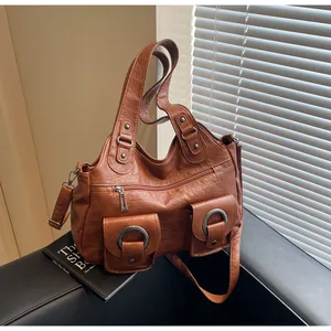 Detail of vintage brown PU leather tote with utility pockets and metal ring accents