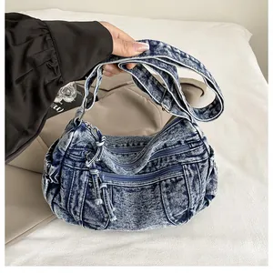Detail of blue snowflake wash denim crossbody bag with dual functional front zippers