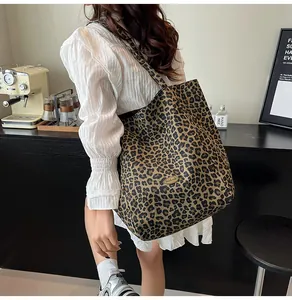 Detail shot of the vintage leopard print canvas tote bag with a handmade metal plaque
