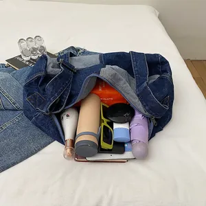 Deep blue denim tote bag with large capacity showing various daily travel essentials