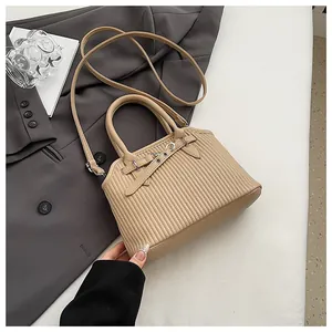 Detail van beige shopper met verticale streeptextuur en metalen gespversiering