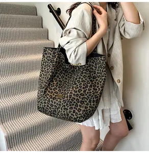 Detailed view of leopard print canvas tote bag with metal logo on high-quality fabric