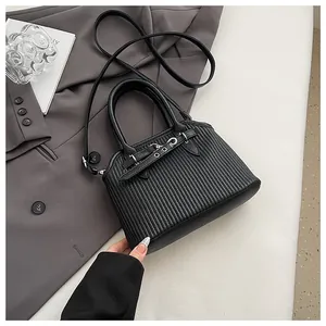 Detail van zwarte tote bag met verticale strepen, metalen gesp en afneembare schouderriem