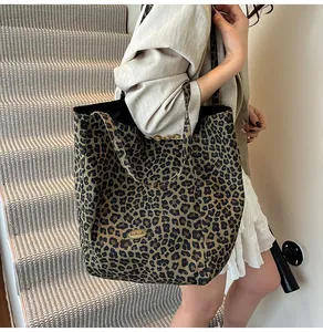 Detail of the leopard print canvas tote bag with a golden handmade metal plaque