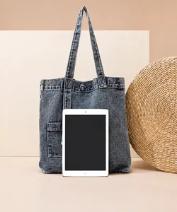 Blaue Denim-Tragetasche neben einem iPad zum direkten Größenvergleich gezeigt