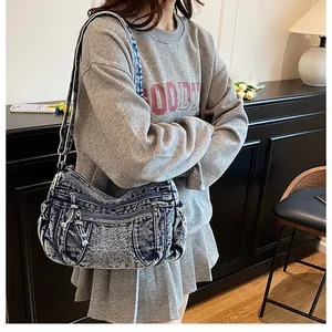 Detail showing retro washed denim hobo bag with multiple zipper pockets and texture