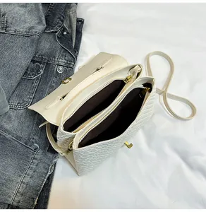 Detail view of woven cream shoulder bag with double zipper and gold hardware