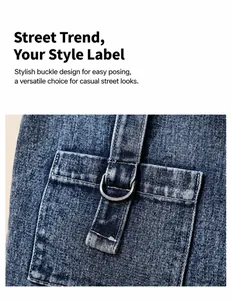 Detail aus blauem Denim-Stoff mit D-Ring-Metallschnalle und verstärkten Taschennähten