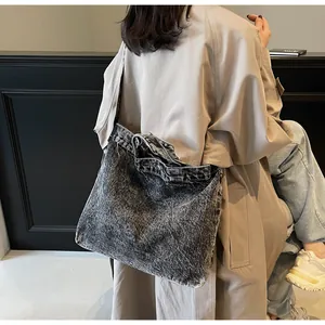 Detailed view of dark grey washed denim tote bag with metallic buttons and vintage texture
