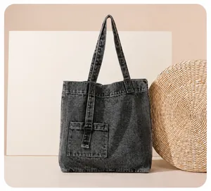 Detailaufnahme der gewaschenen schwarzen Denim-Tragetasche mit Taschen und D-Ring-Verschluss