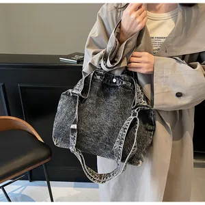Detailed shot of dark grey washed denim tote bag with adjustable shoulder straps and top handles